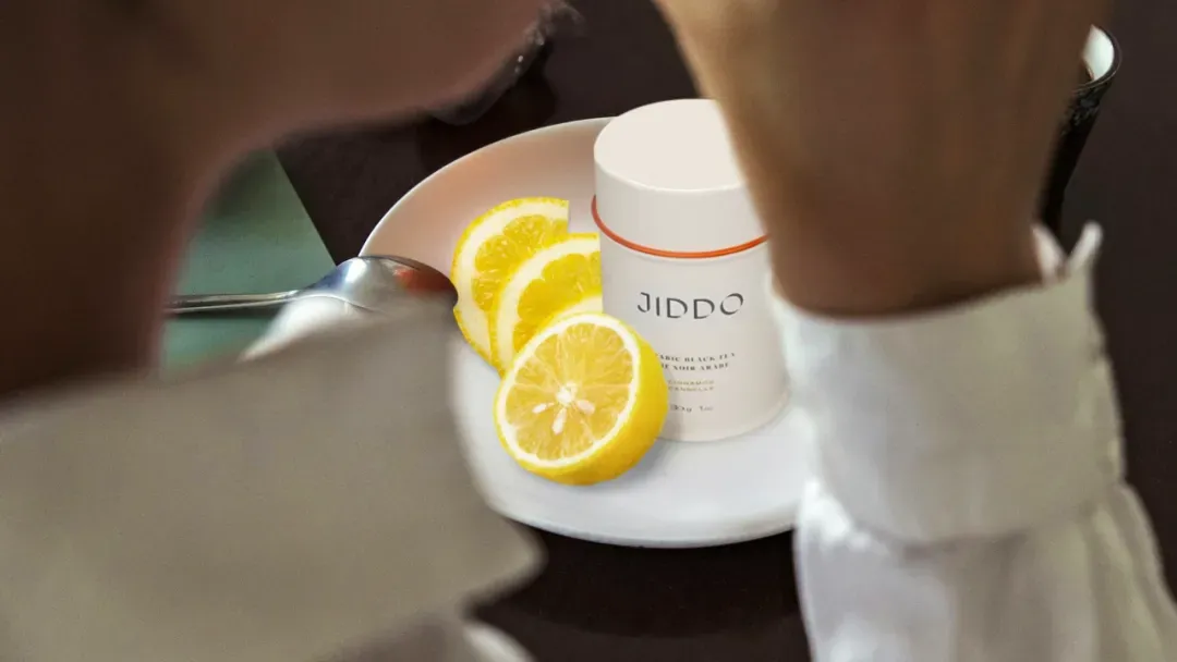 A JIDDO tin beside lemon slices on a saucer