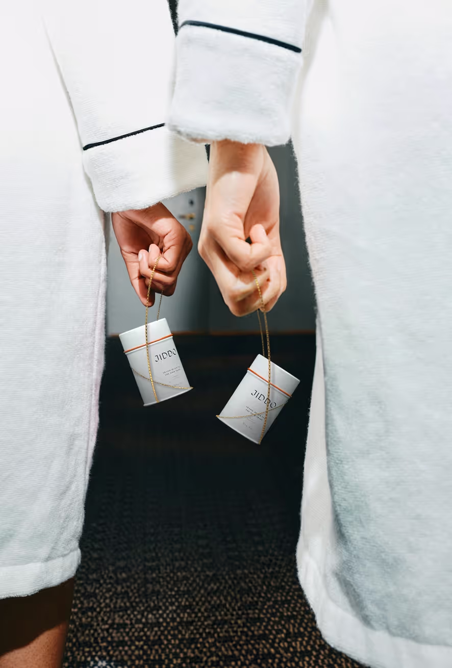 JIDDO sachets held in a hotel robe